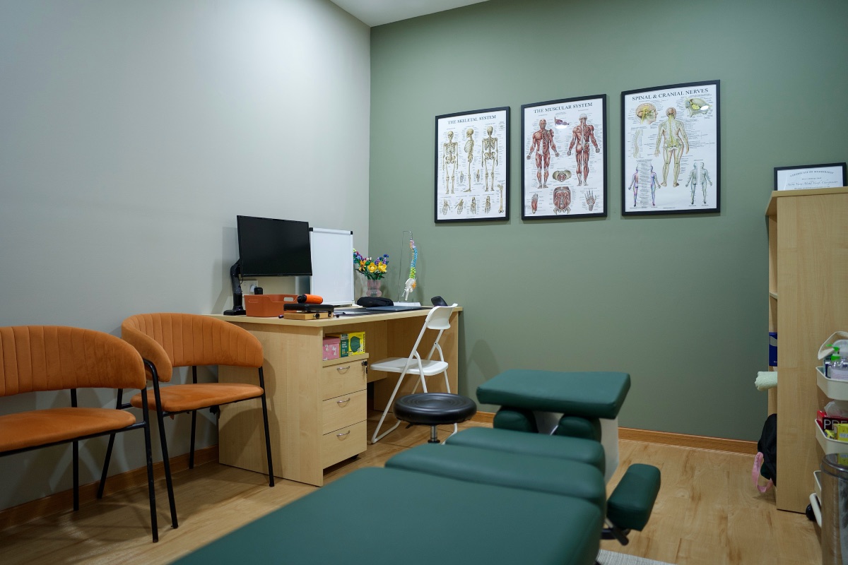 Treatment room with desk and spinal anatomy charts